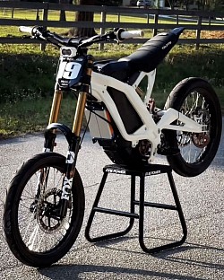 2024 SURRON Light Bee X Electric Bike, also known as Surron LBX. It is an electric dirt bike designed for off-road use.  Top Speed: 45+ mph Range: 20-60 miles per charge, depending on the mode Recharge Time: 2.5-3.5 hours Weight: 125 lbs (57 kg) Climbing Ability: Over 45° License: Some models are street legal and require a license, registration, and insurance. Others are for off-road use only. Features: Near-silent operation, various modes. Displayed on: Fire Power Moto Stand