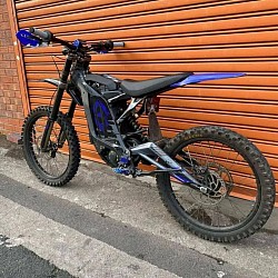 Sur-Ron Light Bee X, an electric dirt bike. Key details include: It's designed for off-road use.  It has a 60V/32AH removable lithium battery.  The range is approximately 100km at 20km/h, but can vary based on riding conditions.  It can reach speeds up to 75 km/h (around 46 mph), with some models reaching higher speeds.  It may not be street legal without modifications.  Aftermarket parts are available and interchangeable with similar bikes.