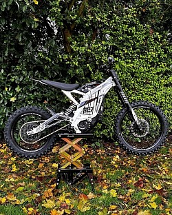 2024 SURRON Light Bee X Electric Bike. Key features include:  Type: Electric off-road bike, blending dirt bike and mountain bike elements.  Performance: Can reach speeds up to 47 mph (73 km/h), varying with load and gearing.  Range: Offers a range of up to 80 miles on a single charge, influenced by riding conditions and battery management.  Battery: Some models feature a 74V battery.  Weight: Weighs approximately 47 kg without the battery.  Upgrades: Can be modified for increased power and performance with upgrades like the X-9000 controller.  Use: Suitable for both beginners and experienced off-road riders.
