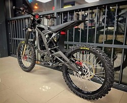 Surron Light Bee X, an electric dirt bike. Key features include:  Type: Electric, blending dirt bike and mountain bike elements. Performance: Top speed of 47 mph (73 km/h), range of 40-80 miles depending on conditions. Weight: Around 103 lbs (47 kg) plus the battery. Motor: Brushless electric motor. Tires: 19-inch spoke wheels with CST tires. Brand: Surron is known for its innovative electric off-road bikes.