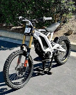 SURRON Light Bee X Electric Bike. Key features include:  Type: Part dirt bike, part mountain bike, all-electric. Speed: Up to 45 mph. Range: Around 40-60 miles on a full charge, can reach up to 80 miles depending on conditions. Weight: 47 kg plus battery. Wheels: 19-inch spoke wheels. Battery: Some models have a 72V 38 amp battery. Customization: Decals and other modifications are common.