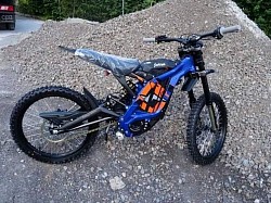 Sur-Ron Light Bee X electric dirt bike. Key features include:  Type: Electric dual-sport dirt bike. Performance: Top speed of 45-55 mph. Range: 40-60 miles on a single charge, depending on riding conditions. Charging: Full charge in 2.5-3.5 hours. Modes: Eco and Sport modes. Legality: Generally not street-legal and designed for off-road use. Age: Can be ridden by people 16 and over with a CBT certificate in some areas.