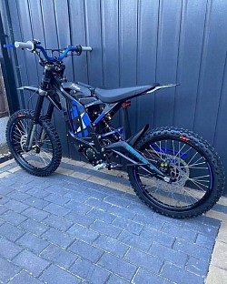 Sur-Ron Light Bee X electric dirt bike. Key features and information include:  Type: Dual-sport electric dirt bike. Brand: Sur-Ron. Model: Light Bee X. Battery: 60V 38Ah. Top Speed: Up to 55 mph. Range: 40-60 miles, depending on riding conditions. Charging Time: 2.5-3.5 hours. Legality: Generally not street legal and intended for off-road use. Age to Ride: 16 and over with a CBT certificate in some regions.