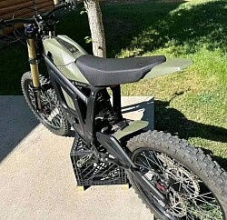 SURRON Light Bee X Electric Bike 2024 or Surron Sting R. Helpful information includes:  It is an electric dirt bike. The bike has a top speed of 45 mph. It can travel 40-60 miles on a full charge. A full charge takes approximately 2.5 - 3.5 hours. It is designed for off-road use but can be street legal with proper modifications. The bike weighs 104 lbs. Minimum rider age is 16 years old, but it can vary based on local laws.