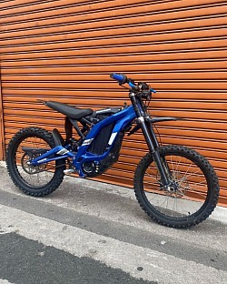 SUR-RON Light Bee X electric dirt bike. Key features and information are:  It is an off-road electric bike. It weighs 50 kg. It has a top speed of 45-59 mph. The range is about 40-80 miles on a single charge, depending on conditions. It has a 60V/32AH removable lithium battery. It may not be street legal in some areas. It features front and rear hydraulic disc brakes. The recharge time is approximately 2.5 to 3.5 hours.