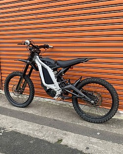 2024 SURRON Light Bee X electric bike. It is a lightweight electric dirt bike known for its agility and off-road capabilities.  Key features include:  Motor: Electric, providing instant torque. Battery: Offers a range of approximately 40-80 miles, depending on riding conditions. Top Speed: Around 47 mph (73 km/h), but some modified versions can reach higher speeds. Weight: Approximately 47 kg plus the battery. Wheels: 19-inch spoke wheels. License: Can be driven with a B or AM license in some regions.