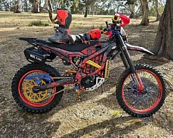 Sur-Ron Ultra Bee, an electric off-road bike. Key features and information about the Sur-Ron Ultra Bee are:  It is designed for off-road use, featuring a robust frame and high-quality components.  The Ultra Bee has a 12.5kW motor with 440Nm of torque and can reach a top speed of 90 km/h.  It has a range of 140km when cruising at 40 km/h.  The Sur-Ron Ultra Bee is classified as L3E (125cc equivalent) in the UK, requiring riders to be at least 16 years old and have a CBT or A1 license.  It is not street-legal in some areas and is primarily intended for off-road use.  Modifications, like those seen in the image, are common, with some reaching 50kW of power.