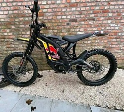 SURRON Light Bee X Electric Bike. Key features include:  Type: Electric dirt bike. Brand: SURRON. Model: Light Bee X. Range: 40-80 miles on a single charge, depending on conditions. Top Speed: Up to 47 mph (73 km/h). Weight: 47 kg plus battery. Features: Spoke wheels with 19 x 1.4 alloy hubs. Front/Rear 70/100-19 CST tires. Custom-built, titanium-gold, four-piston brakes. Gold oil seal chain. Red Bull branding. CHROMEBUR branding.