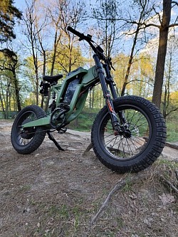 EKX X21 electric bike. Key features include:  Motor: 2000W Range: Up to 75 miles Battery: 48V 35Ah Speed: Can reach up to 28 mph Design: Combines vintage aesthetics with modern components Use: Suitable for off-road and potentially urban environments Classification: Likely a Class 2 or 3 e-bike, depending on speed and throttle Weight: Around 45kg/56kg